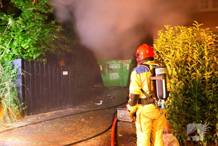 Bouwcontainer vat vlam naast woning met rietendak