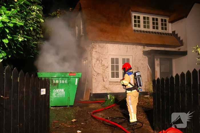 Bouwcontainer vat vlam naast woning met rietendak