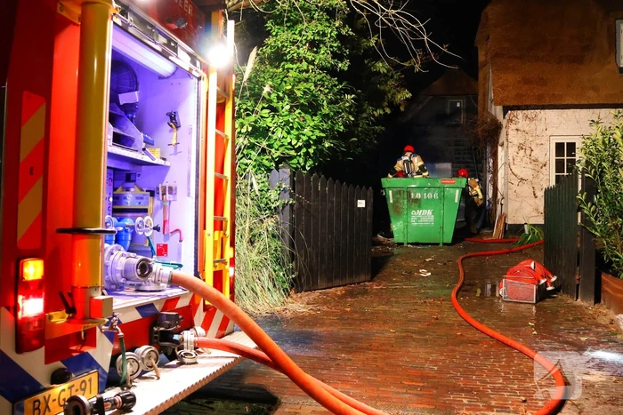 Bouwcontainer vat vlam naast woning met rietendak