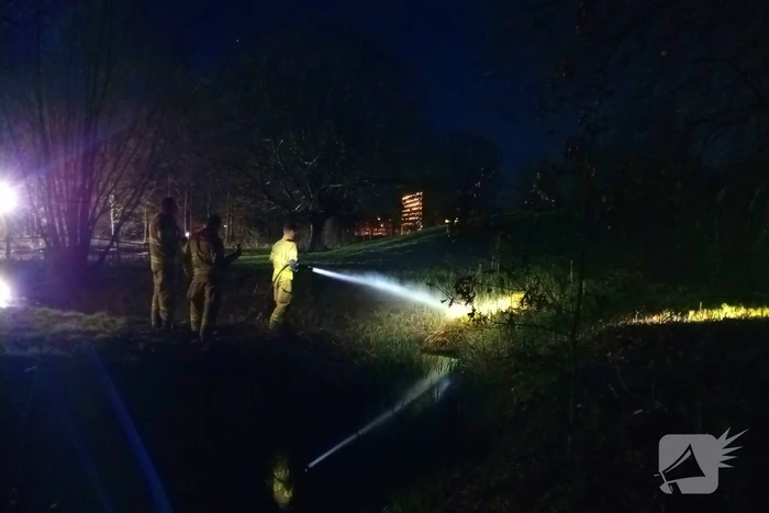 Brandweer blust brandend riet