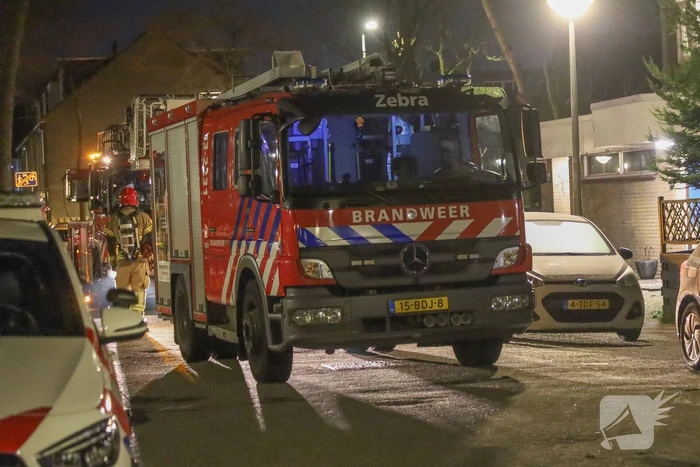 Explosie bij portiek van flatgebouw, brandweer blust vuurhaard