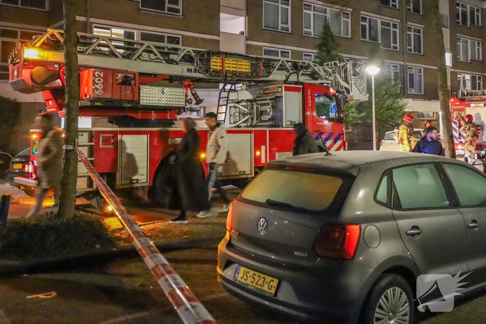 Explosie bij portiek van flatgebouw, brandweer blust vuurhaard