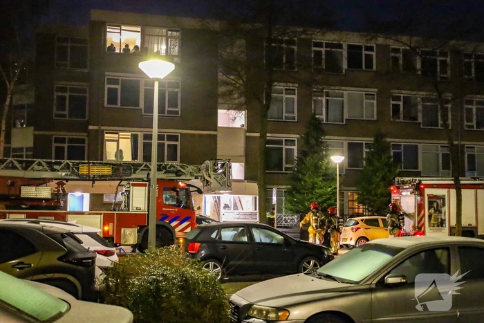 Explosie bij portiek van flatgebouw, brandweer blust vuurhaard