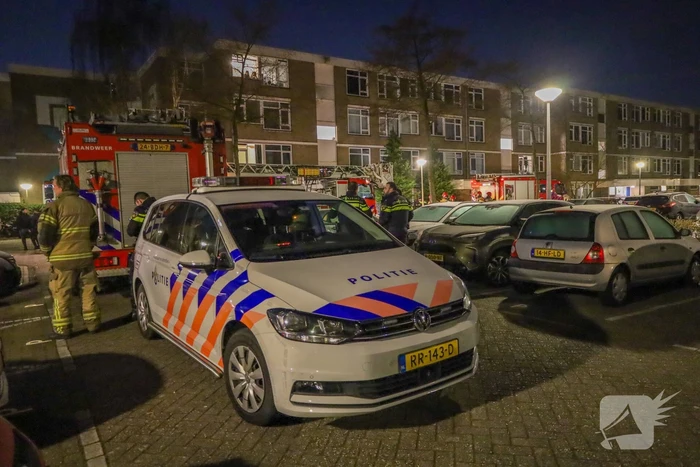 Explosie bij portiek van flatgebouw, brandweer blust vuurhaard