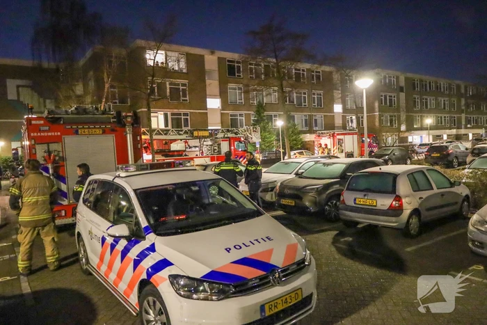 Explosie bij portiek van flatgebouw, brandweer blust vuurhaard