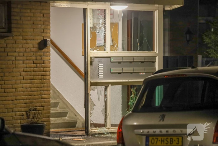 Explosie bij portiek van flatgebouw, brandweer blust vuurhaard