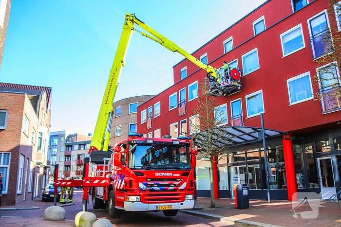 Duif gered uit benarde positie achter glazen balustrade