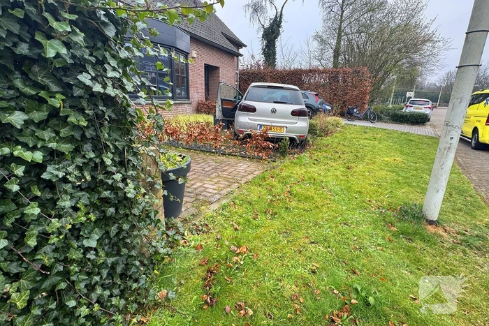 Automobilist rijdt voortuin in