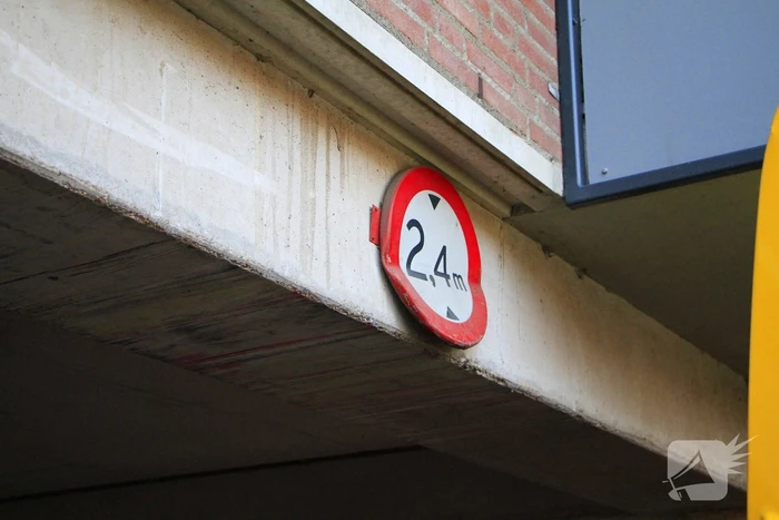 DHL-bezorger rijdt zichzelf vast onder appartementen