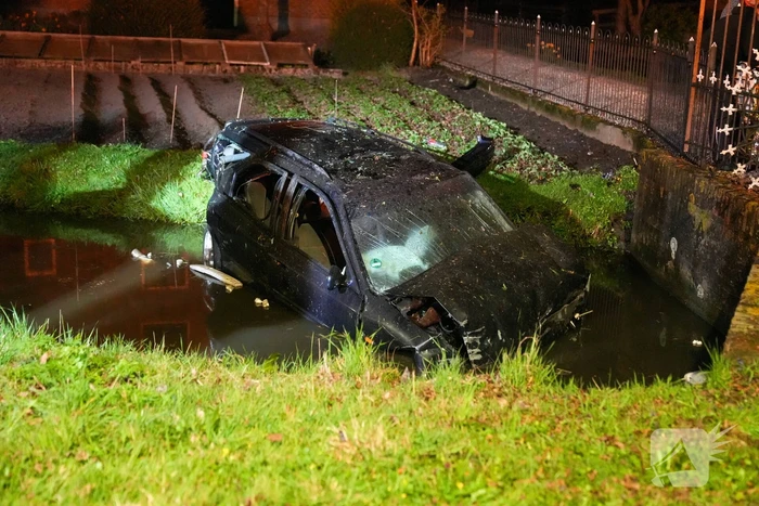 Auto raakt bij botsing met boom te water