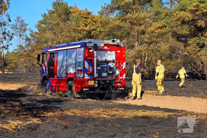 Brandweer blust smeulende resten in afgebrande heidegebied