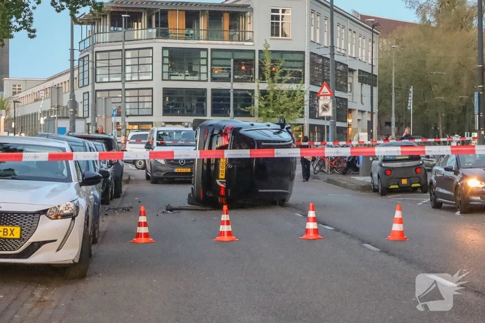 Auto botst op drie geparkeerde auto's en belandt op zijkant