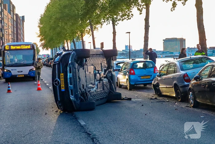 Auto botst op drie geparkeerde auto's en belandt op zijkant