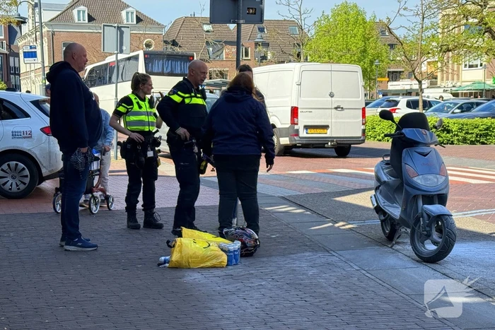 Omstanders blussen brandende scooter