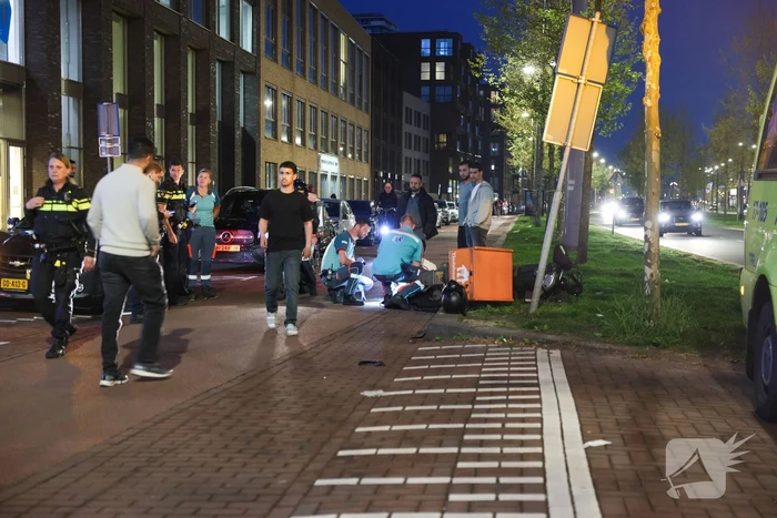 Maaltijdbezorger klapt tegen auto en komt ten val