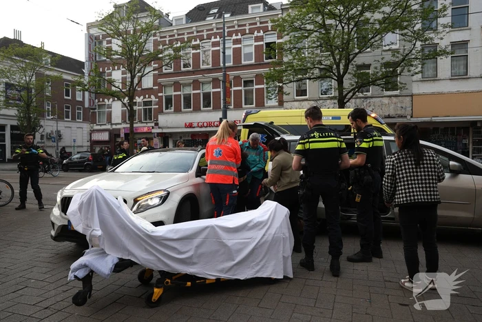 Persoon bekneld tussen twee voertuigen