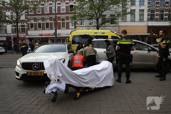 Persoon bekneld tussen twee voertuigen