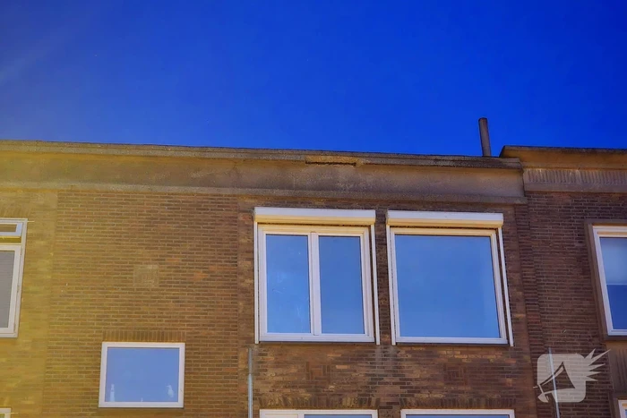 Brokstukken op stoep van gevel