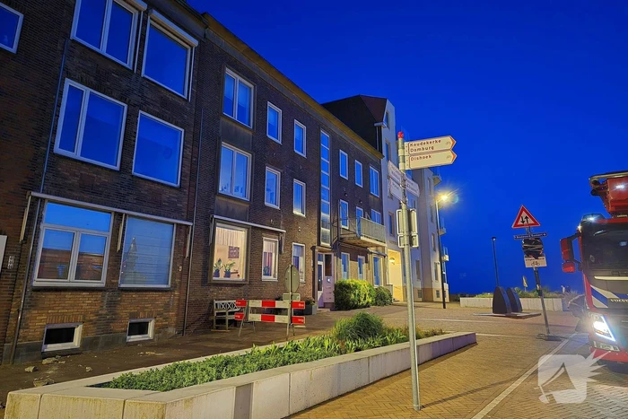 Brokstukken op stoep van gevel
