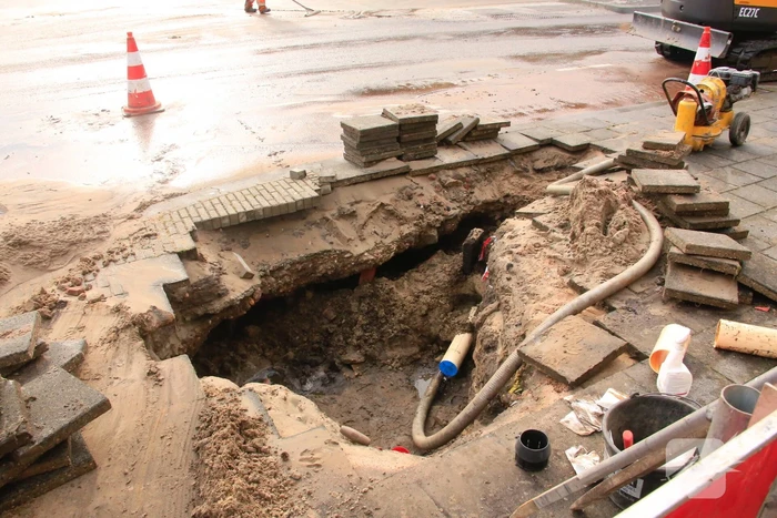 Straat onder water door gesprongen leiding