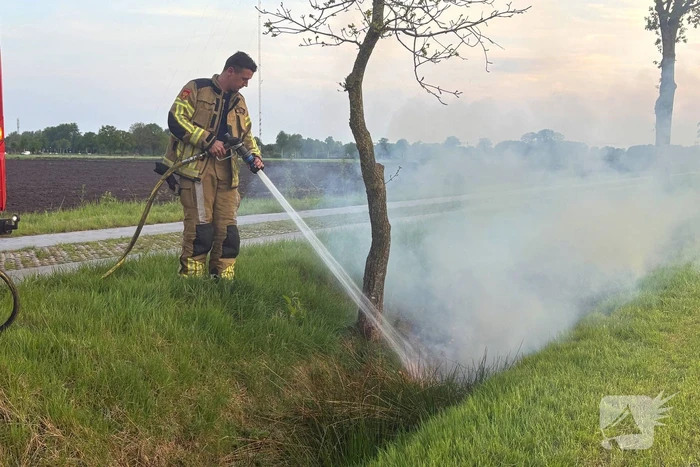 Brandweer blust brand in berm