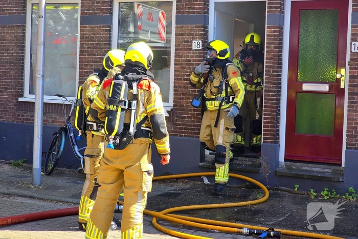 Brandweer slaat raam in wegens brand