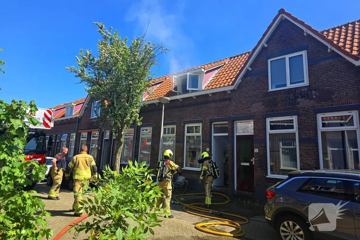 Brandweer slaat raam in wegens brand