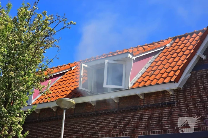 Brandweer slaat raam in wegens brand