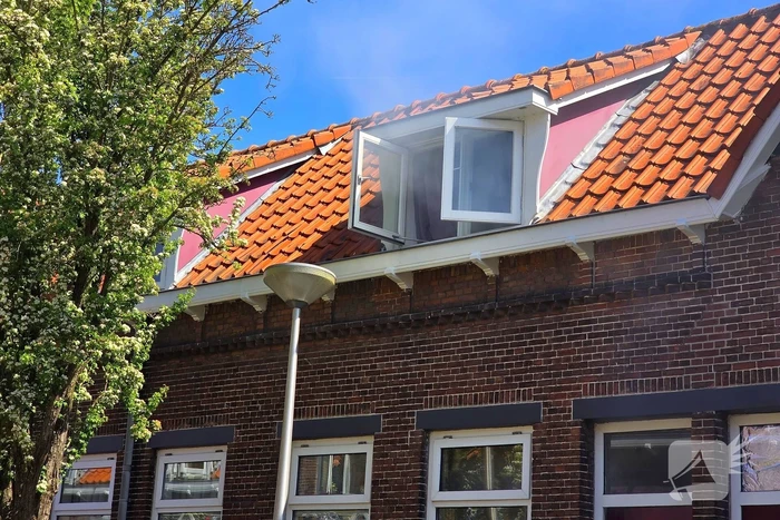 Brandweer slaat raam in wegens brand