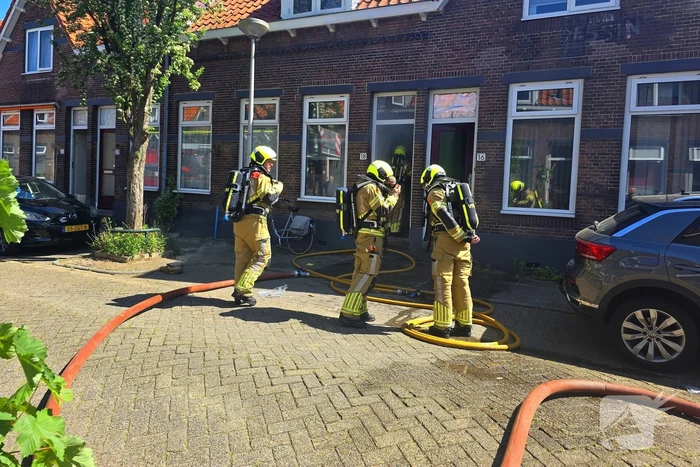 Brandweer slaat raam in wegens brand