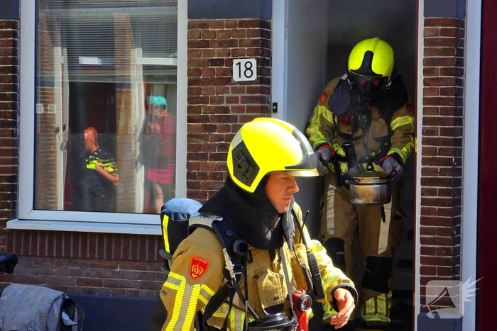 Brandweer slaat raam in wegens brand