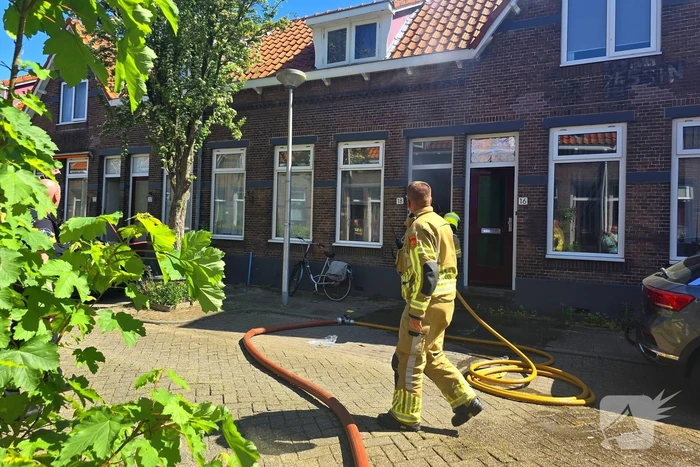 Brandweer slaat raam in wegens brand