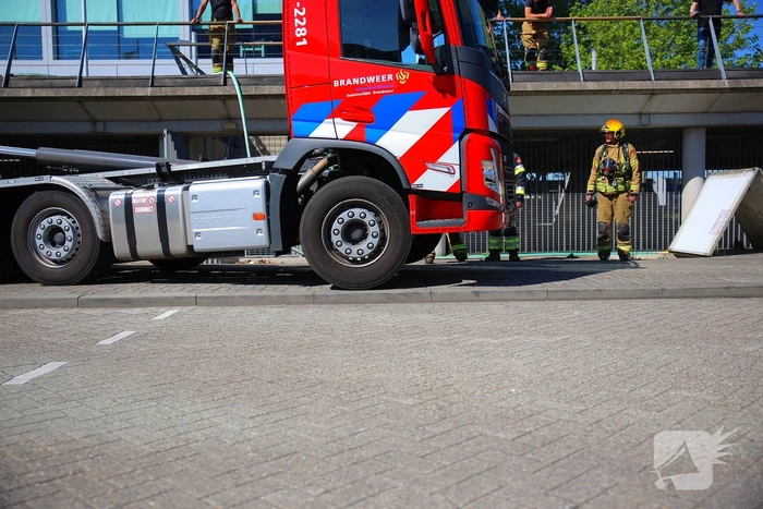 Vlammen slaan uit grote afvalcontainer