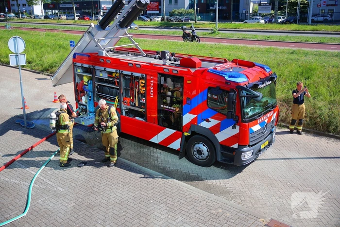 Vlammen slaan uit grote afvalcontainer