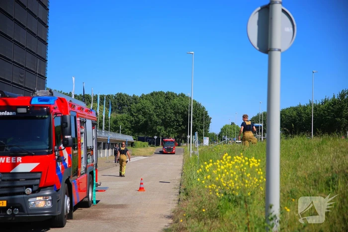 Vlammen slaan uit grote afvalcontainer