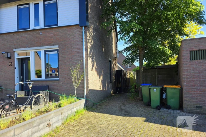 Schutting naast woning in brand