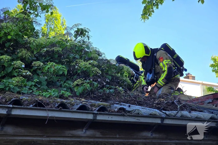 Brandweer blust brand in dak