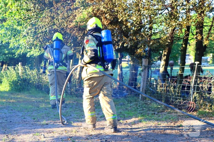 Bomen en pipowagen in brand
