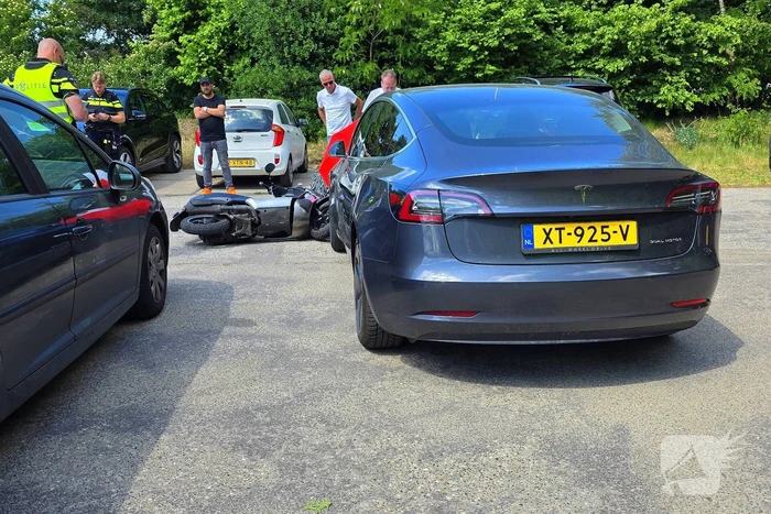 Scooterrijder botst tegen Tesla op parkeerplaats