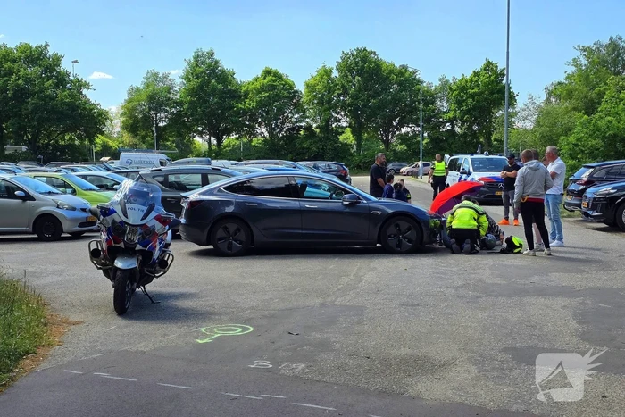 Scooterrijder botst tegen Tesla op parkeerplaats