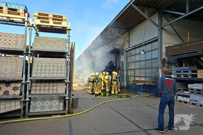 Palletopslag in brand, gebouw bedreigt