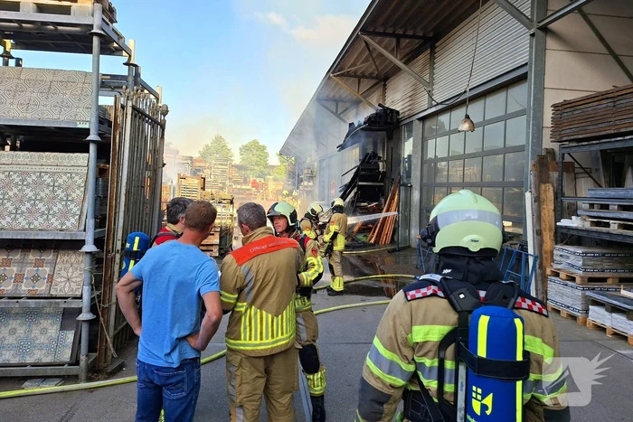 Palletopslag in brand, gebouw bedreigt