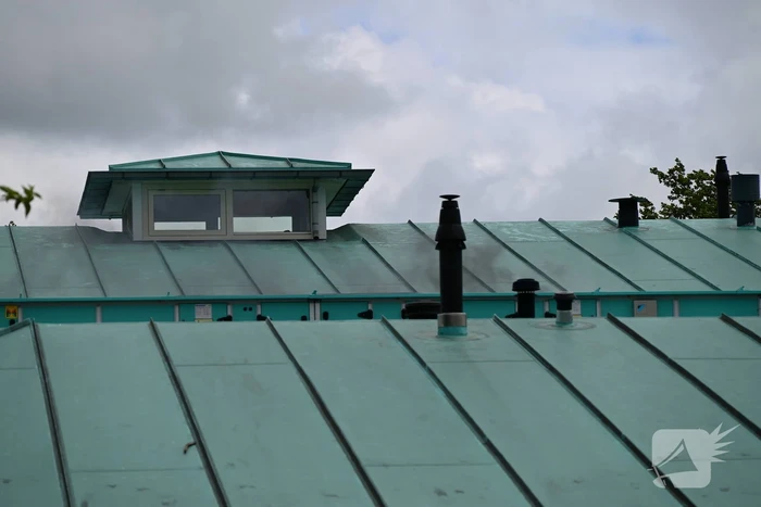 Rook uit dak van schoolgebouw