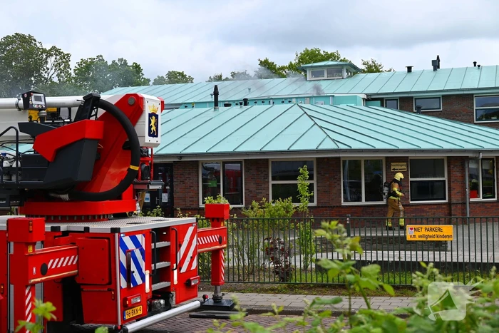 Rook uit dak van schoolgebouw