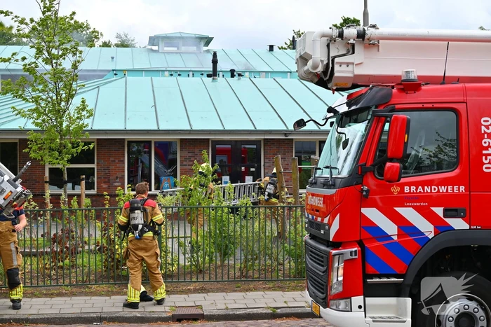 Rook uit dak van schoolgebouw
