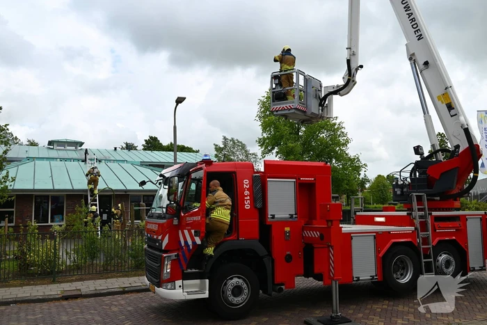 Rook uit dak van schoolgebouw