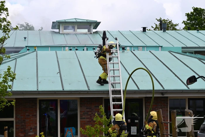 Rook uit dak van schoolgebouw