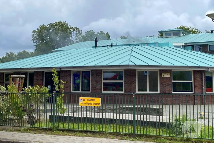 Rook uit dak van schoolgebouw