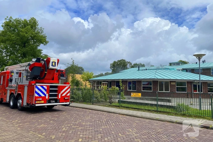 Rook uit dak van schoolgebouw
