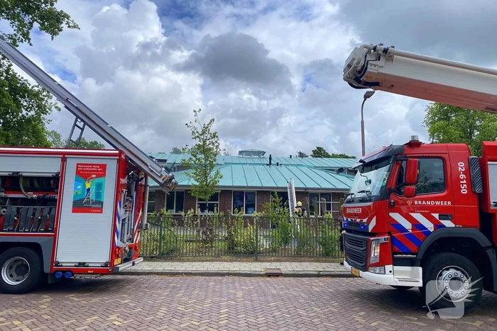 Rook uit dak van schoolgebouw